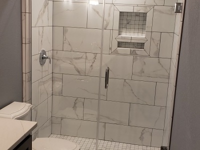 Marble shower with Kolher mixer and glass shower door