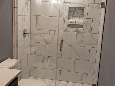 Marble shower with Kolher mixer and glass shower door
